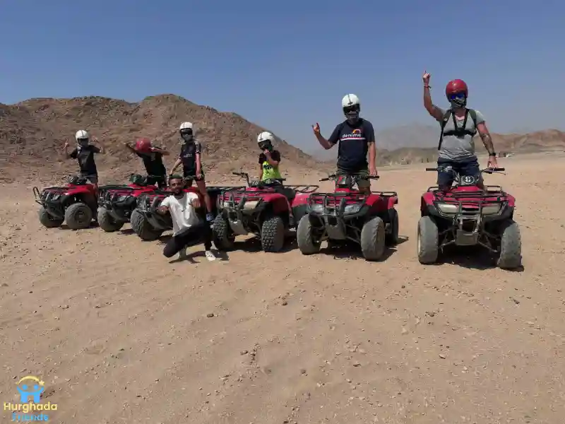 مجموعة من السياح يلتقطون صورة تذكارية مع دراجات الرباعية (البيتش باجي)